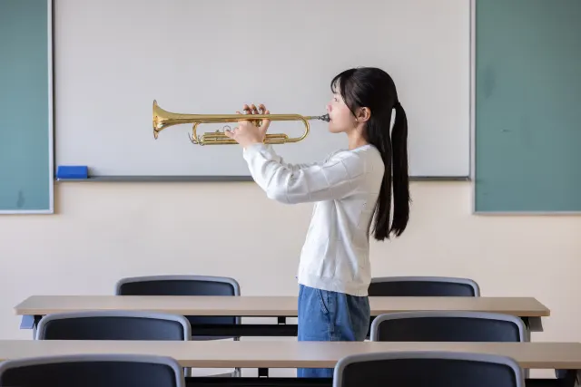 教室でトランペットを演奏する学生